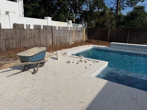 Travertine pool deck and pool pavers installed by Fénix Paver Landscape, 30A FL