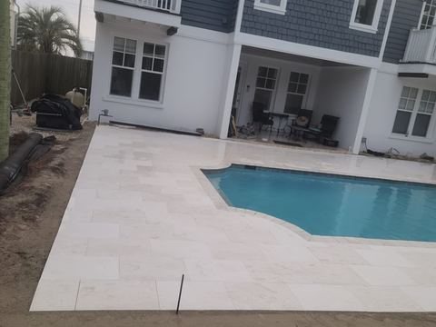 Travertine pool deck and pool pavers installed by Fénix Paver Landscape, Emerald Coast FL