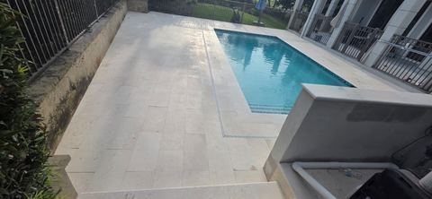 Travertine pool deck and pool pavers installed by Fénix Paver Landscape, Destin FL