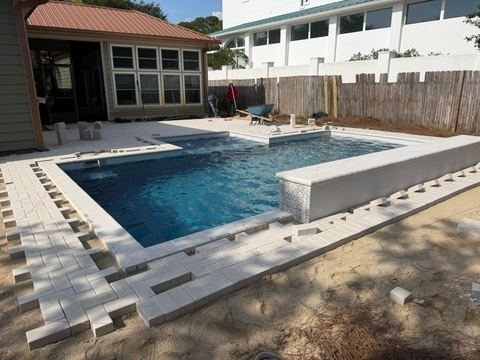 Travertine pool deck and pool pavers installed by Fénix Paver Landscape, Miramar Beach FL